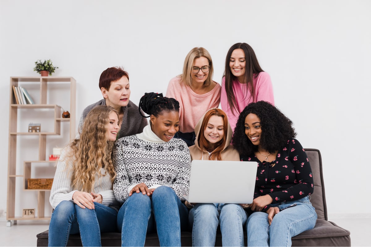 A group of mother looking at a laptop